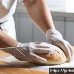 제과제빵 현장 경험이 필요한 이유 - A close-up scene of a skilled Japanese baker’s hands gently kneading soft, slightly moist bread doug...